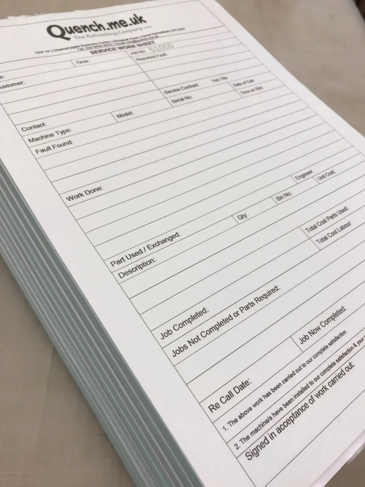 Stack of printed service work sheets on desk
