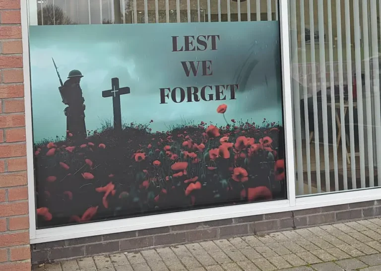 Lest We Forget poster with soldier, cross and poppies