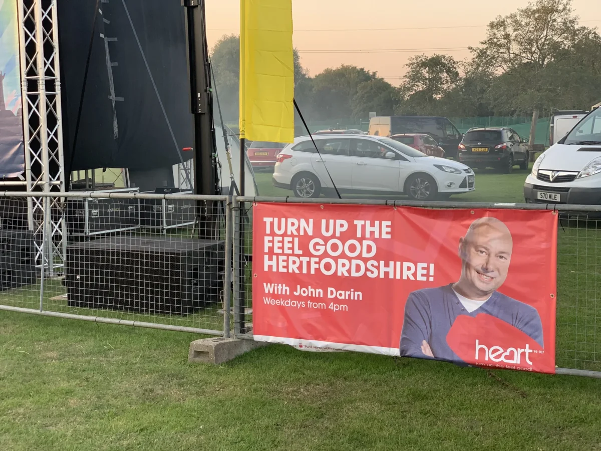 Heart Hertfordshire banner beside an outdoor event stage