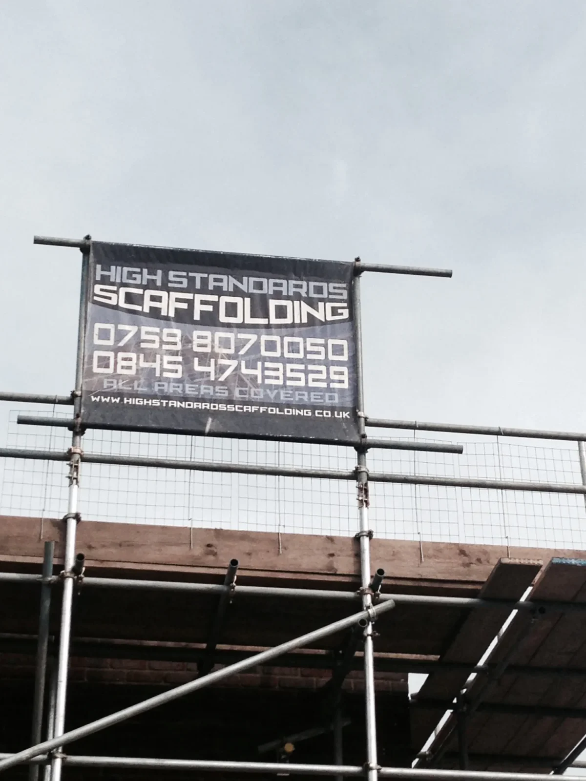 High Standards Scaffolding banner displayed on construction site scaffolding