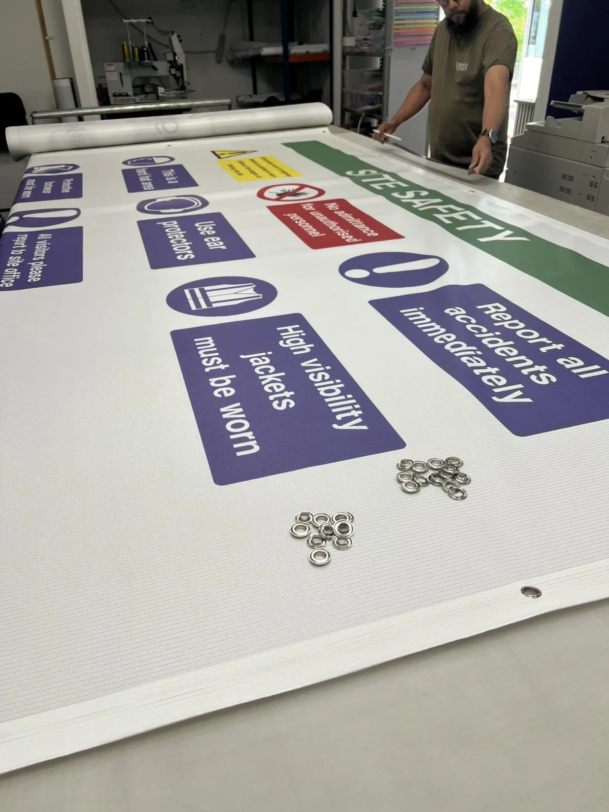 Worker producing a printed construction site safety banner