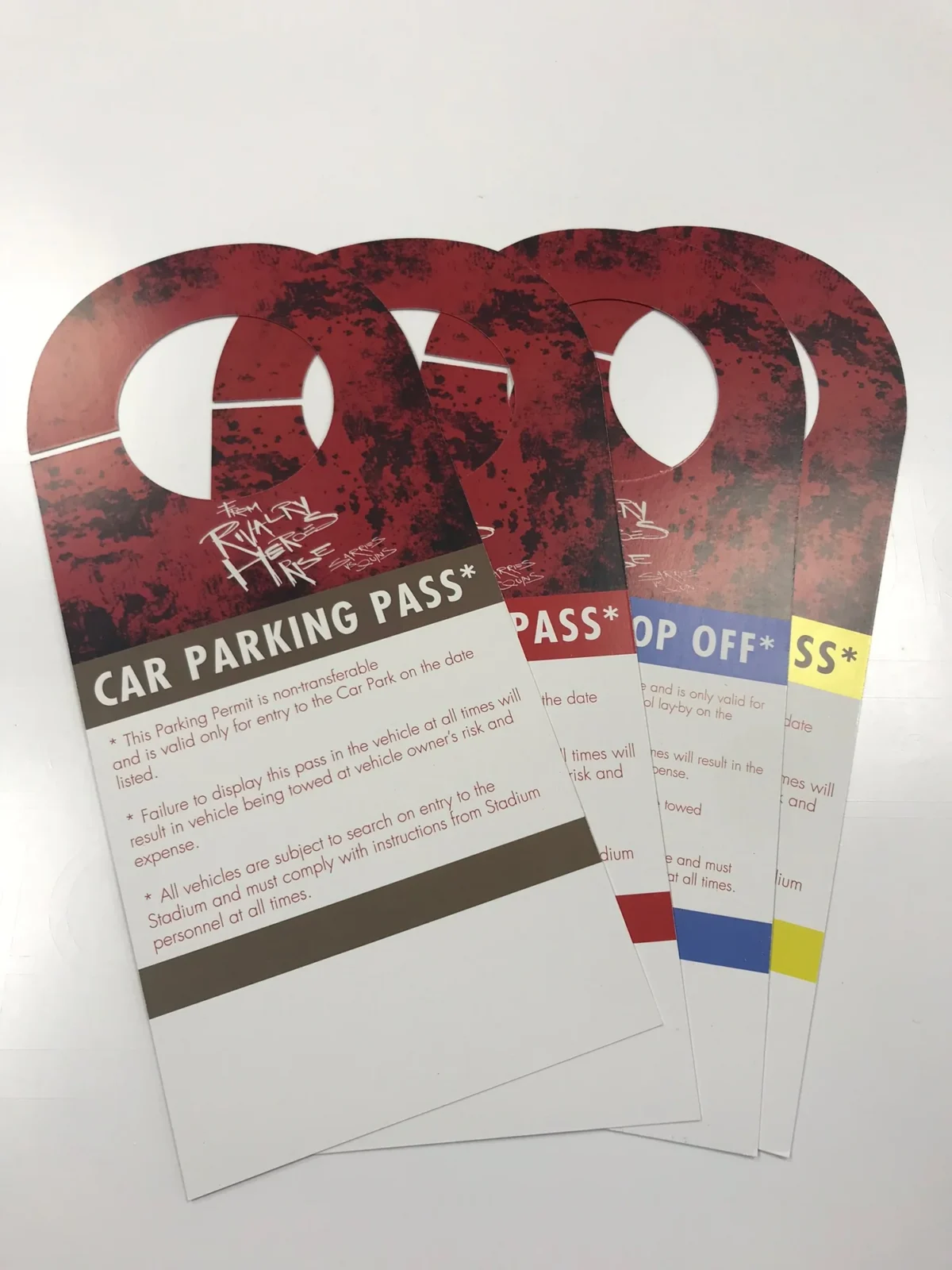 Four red stadium car parking passes with coloured labels