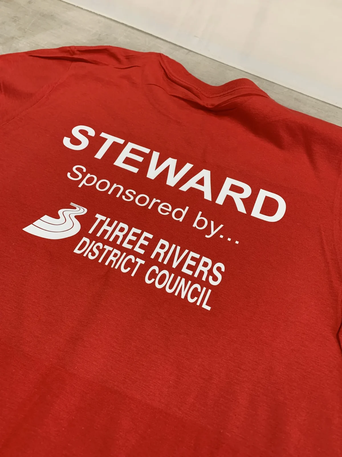 Red steward T-shirt sponsored by Three Rivers District Council