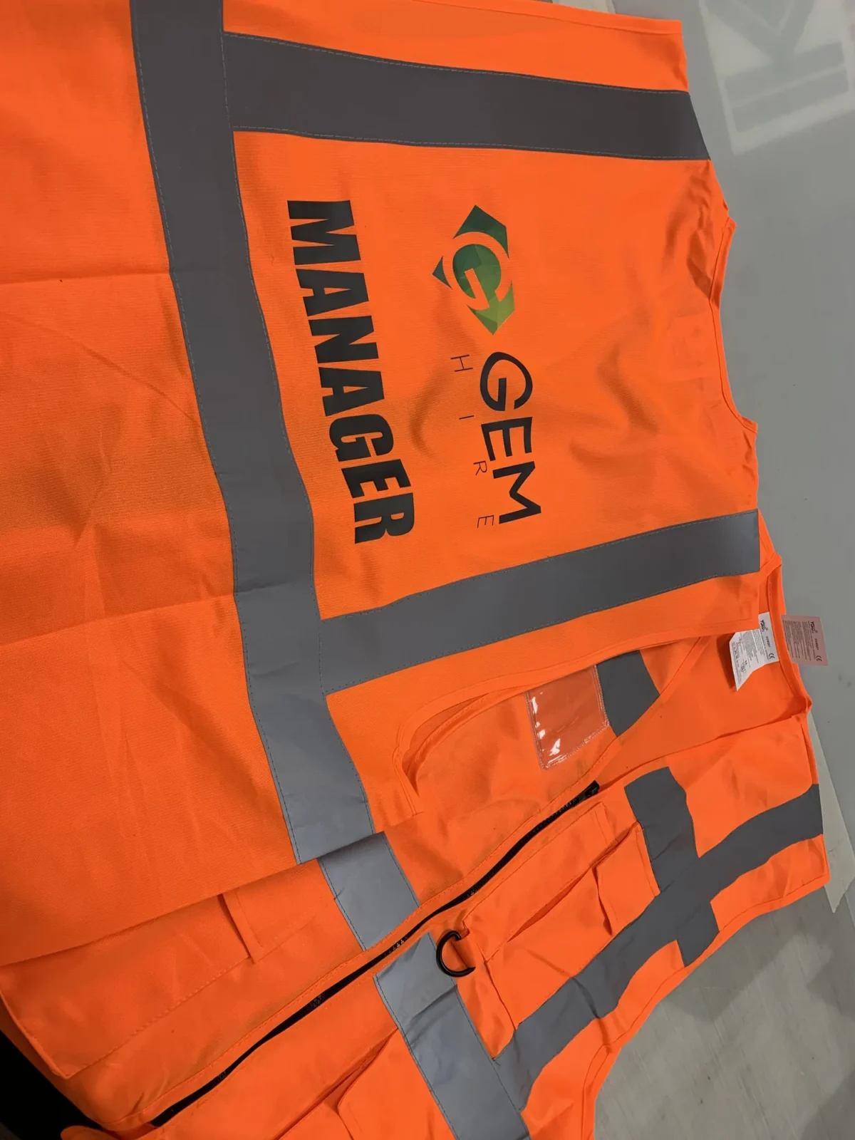Orange hi-vis jacket with MANAGER and GEM Hire branding