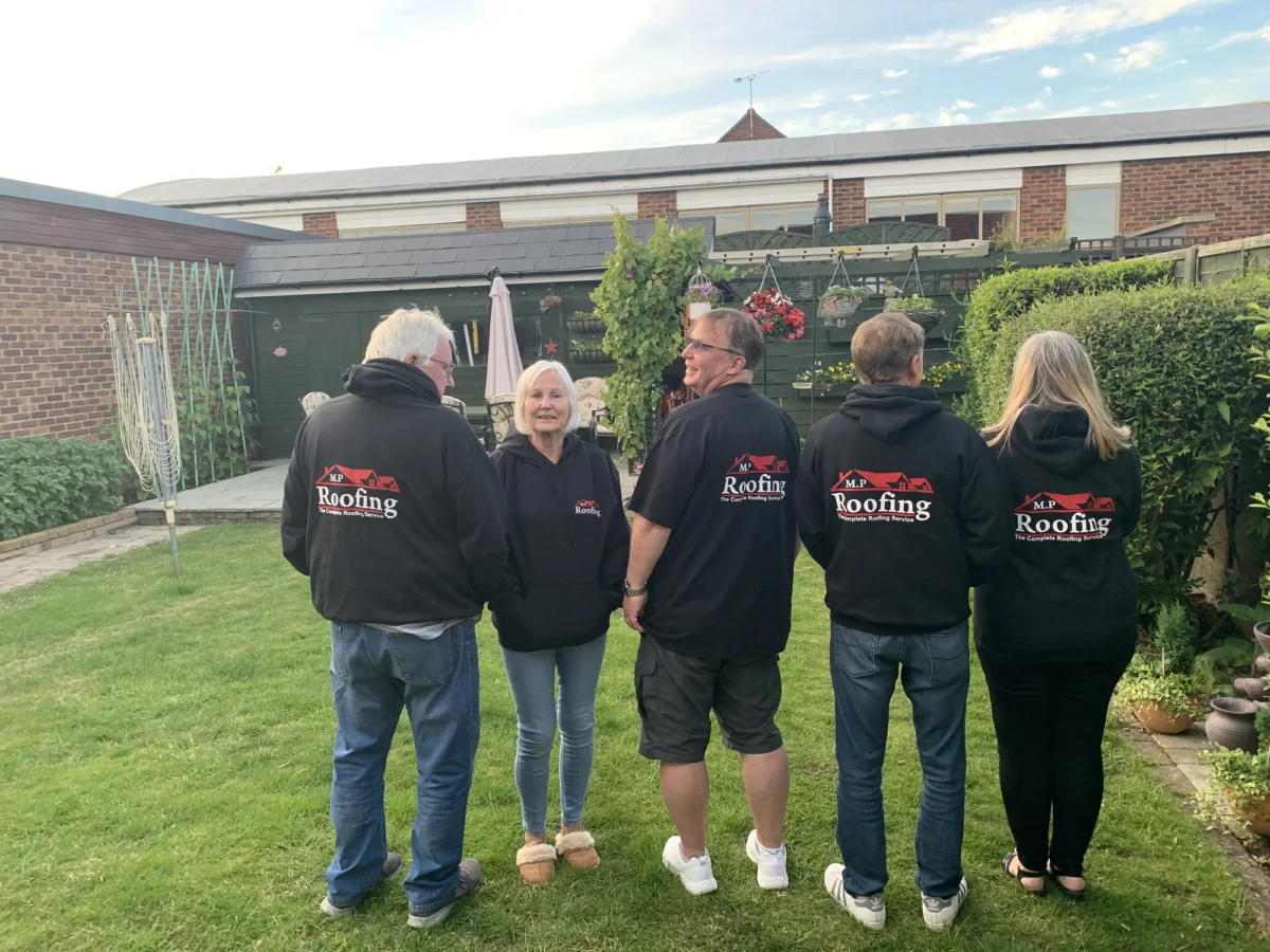 MP Roofing team members standing together in a garden