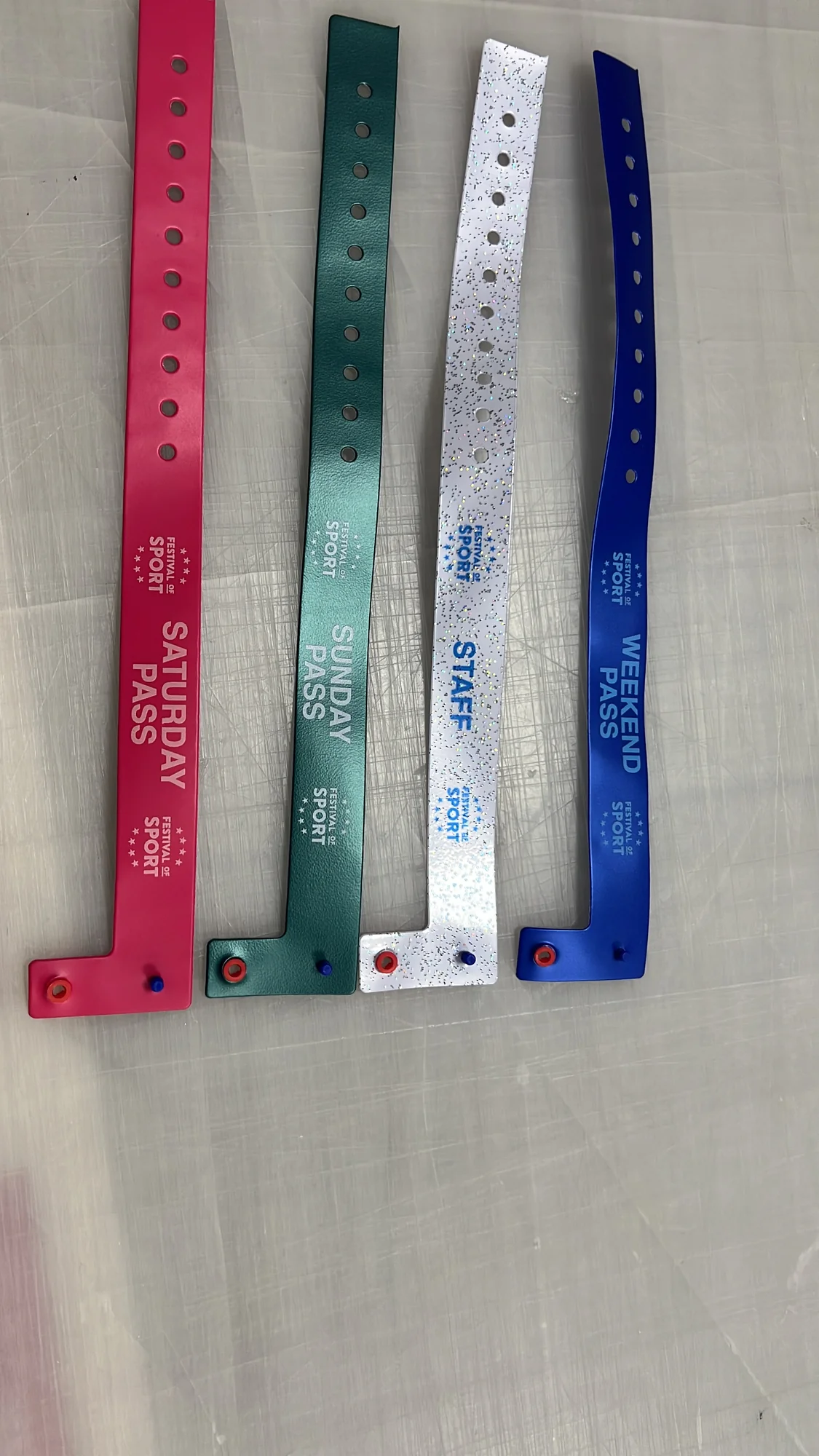Four colourful festival wristbands labelled Saturday, Sunday, staff and weekend