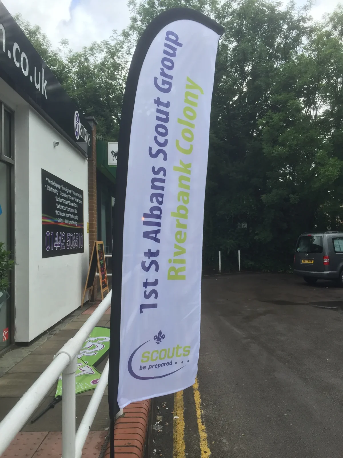 Scout Group banner advertising Riversidebank Colony outside building