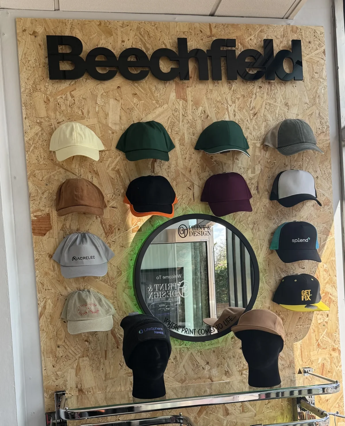 Beechfield branded cap display on wooden wall