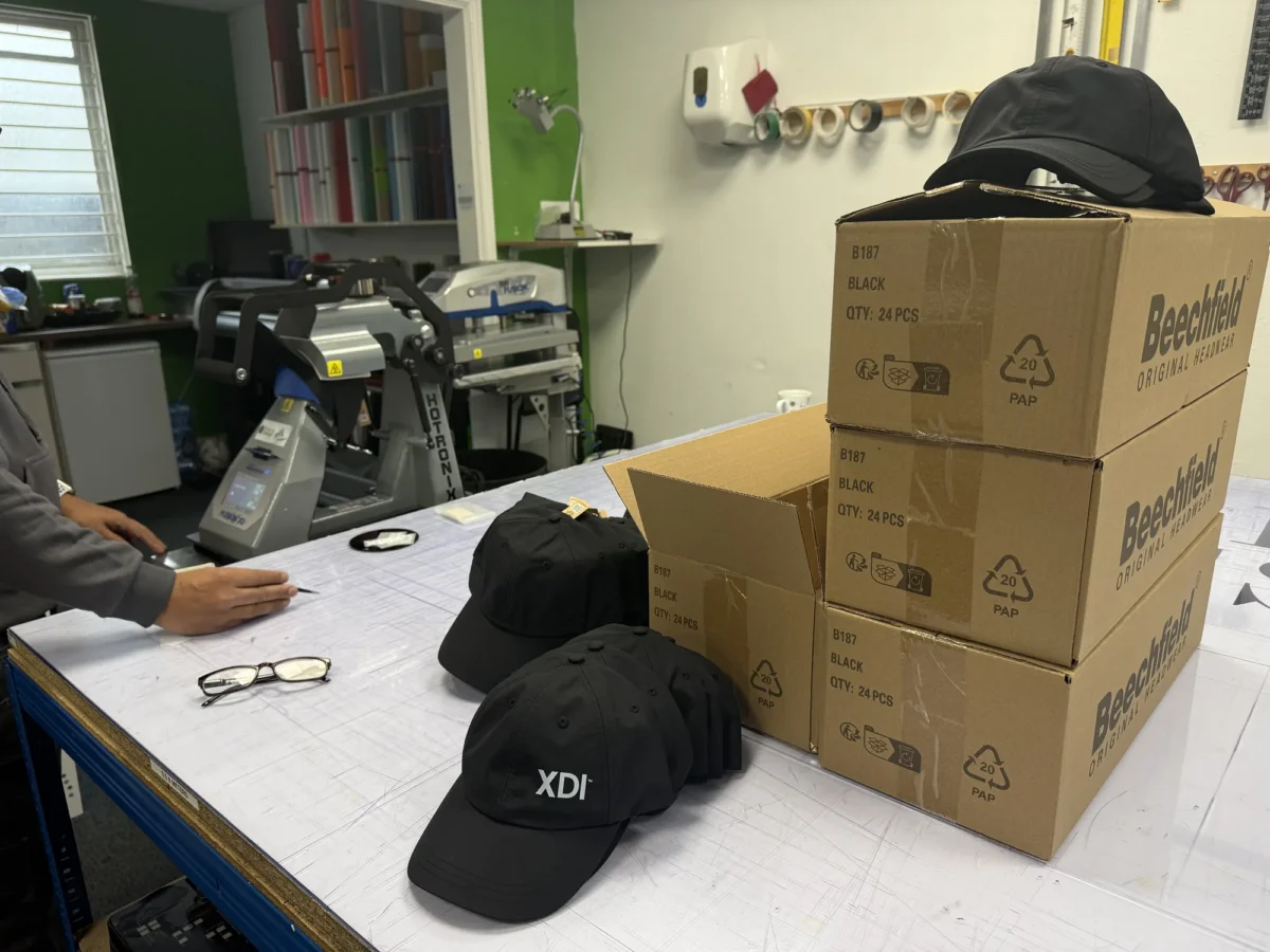 Black caps and Beechfield boxes in printing workshop