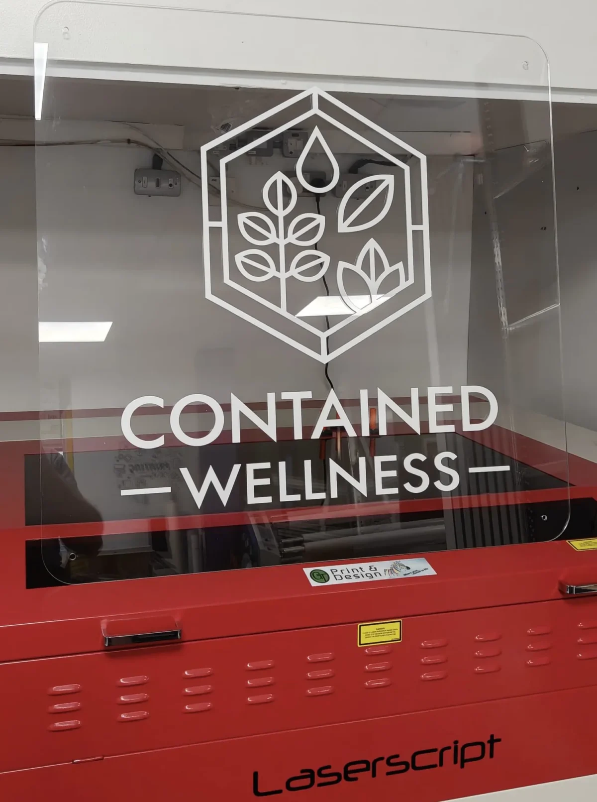 Contained Wellness logo with leaves on laser engraving machine