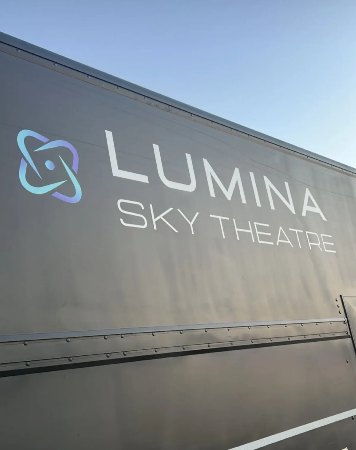 Lumina Sky Theatre logo on dark grey trailer
