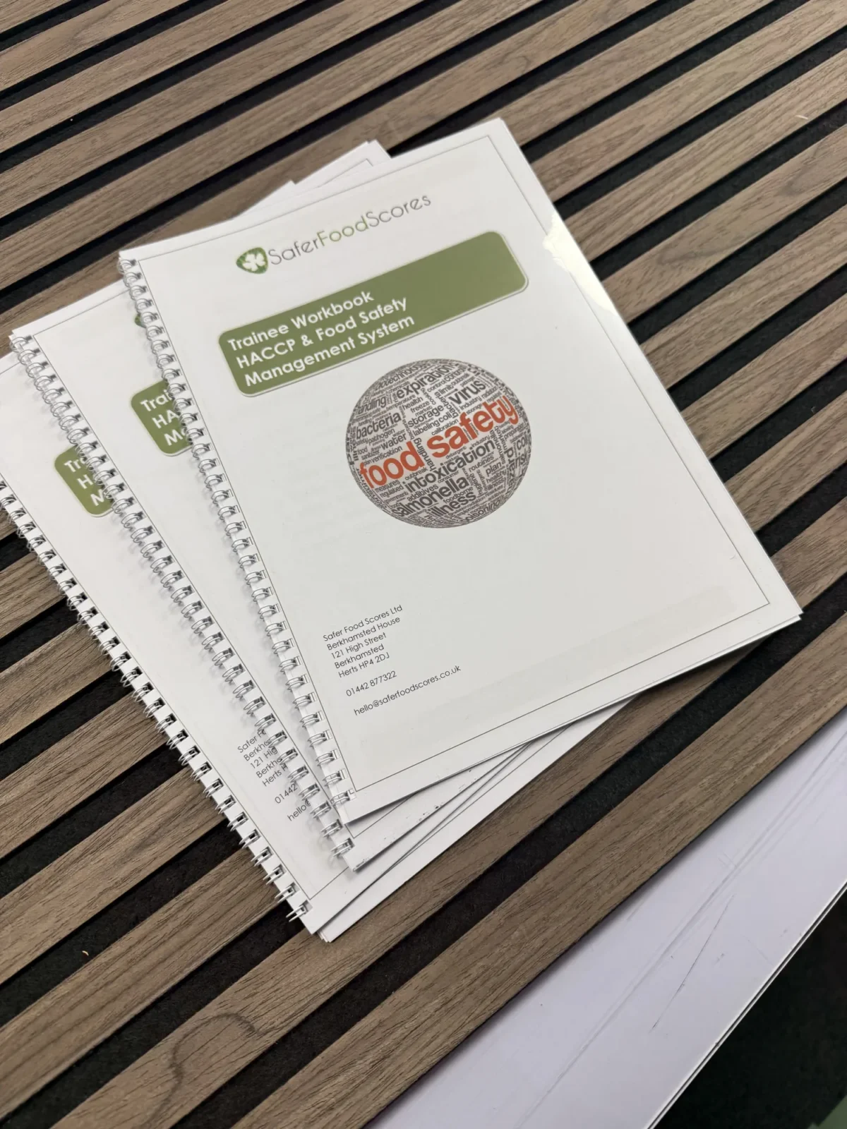 HACCP food safety trainee workbooks on wooden table