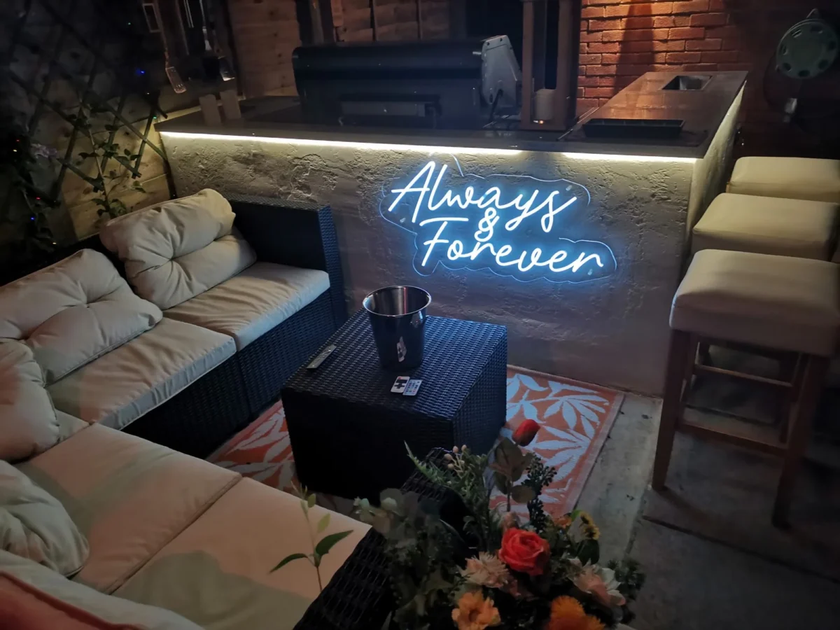 Cosy lounge seating beneath an ‘Always and Forever’ neon sign