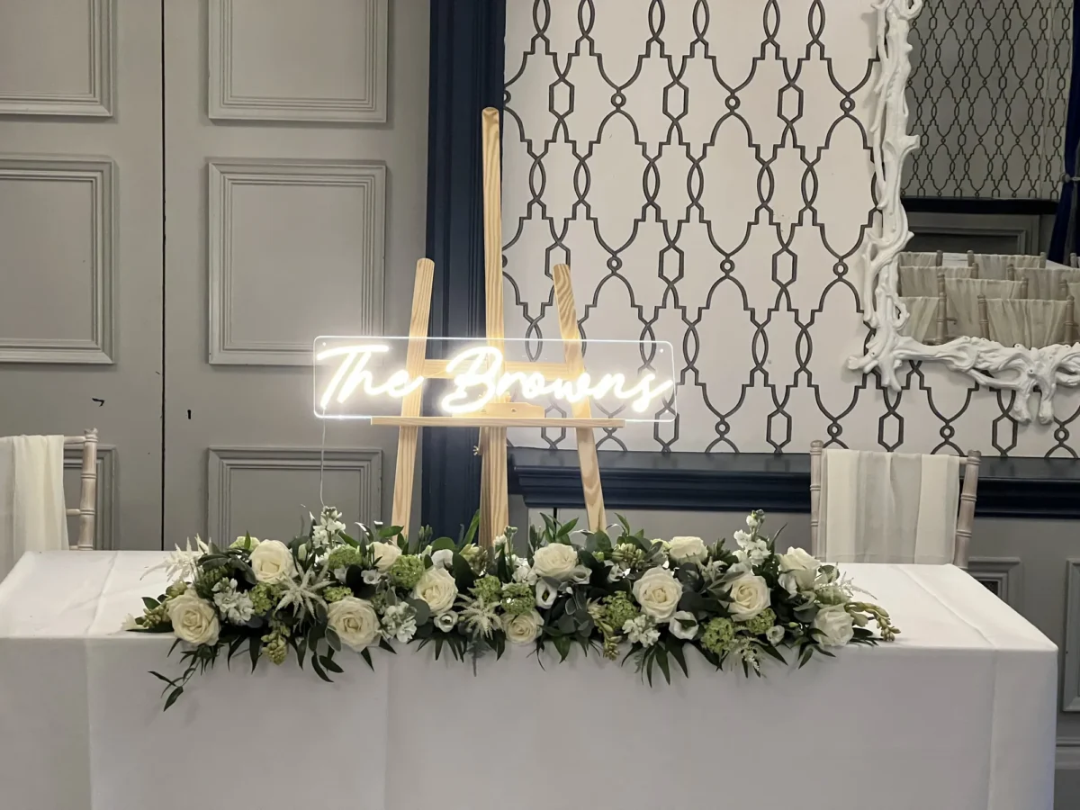 Wedding table with white flowers and glowing neon sign