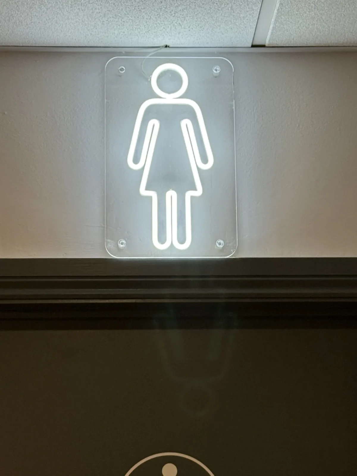Women’s toilet sign on a grey wall