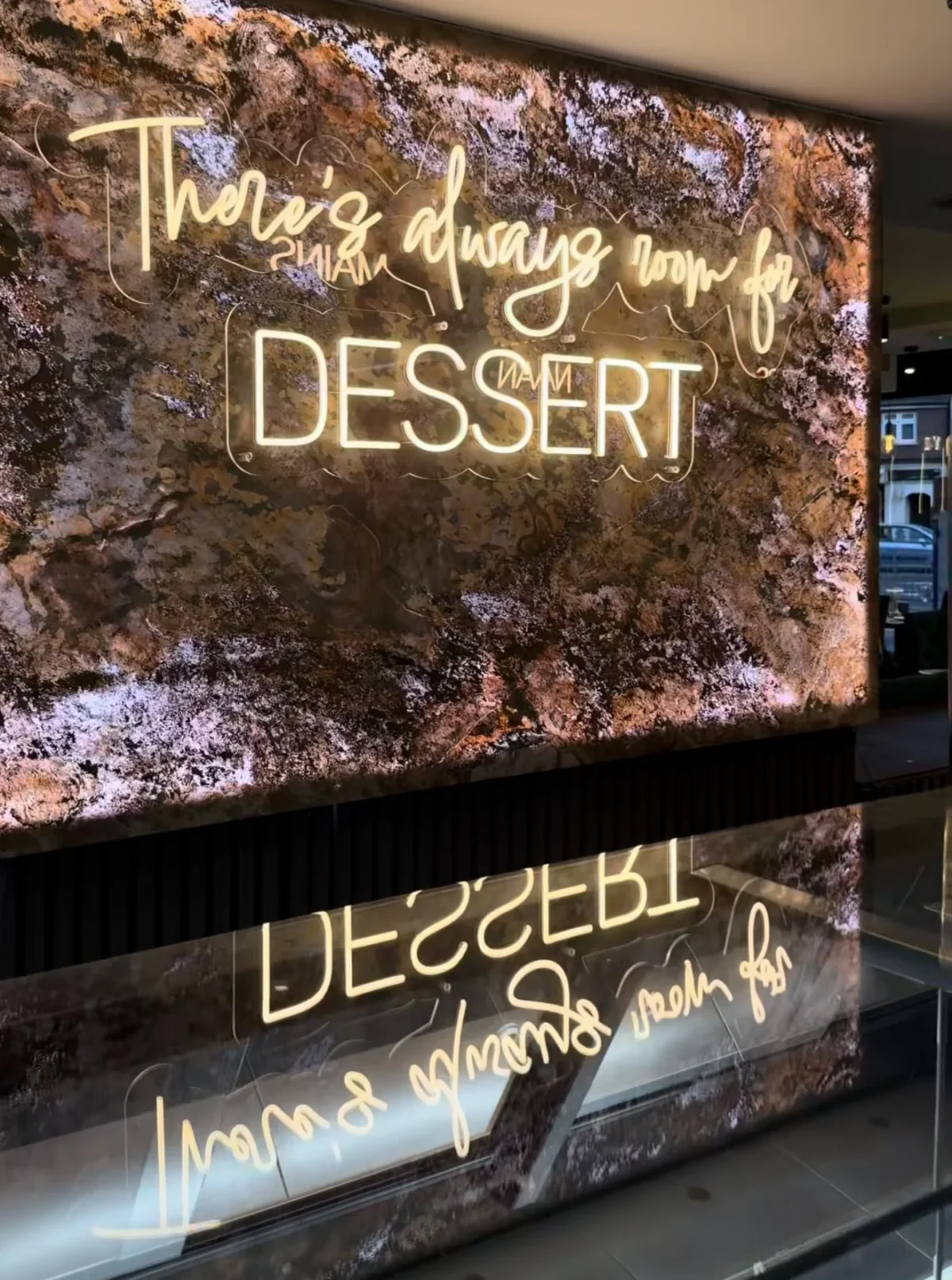 Illuminated dessert slogan on textured restaurant wall
