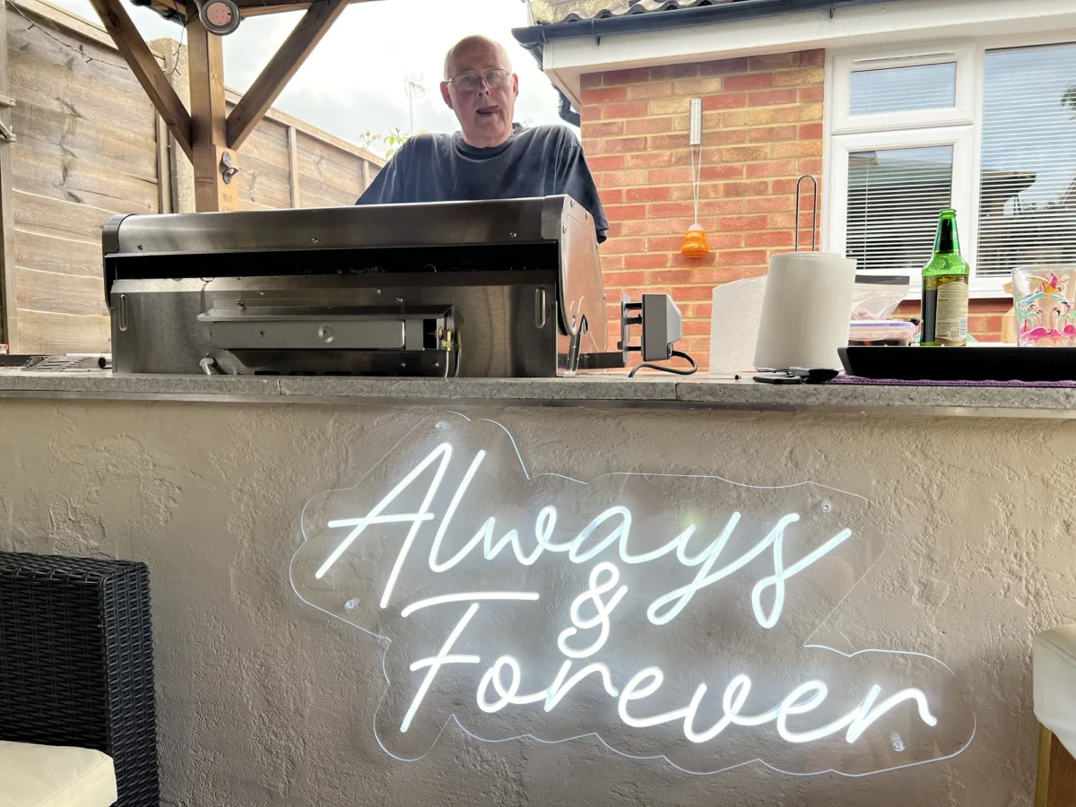 Man standing behind outdoor barbecue grill at garden bar