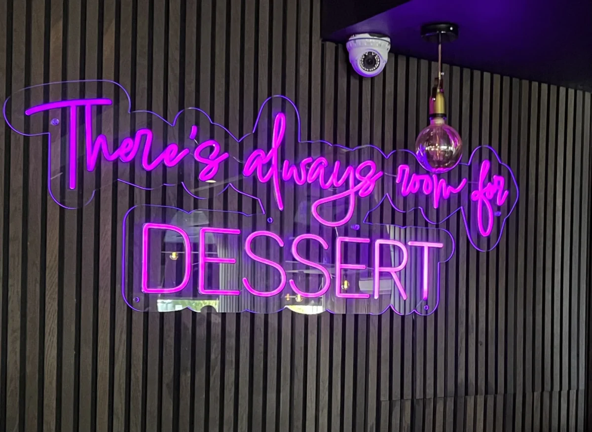 Purple neon 'There’s always room for dessert' sign