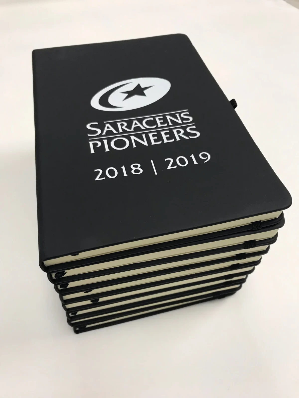 Stack of Saracens Pioneers 2018–2019 black notebooks