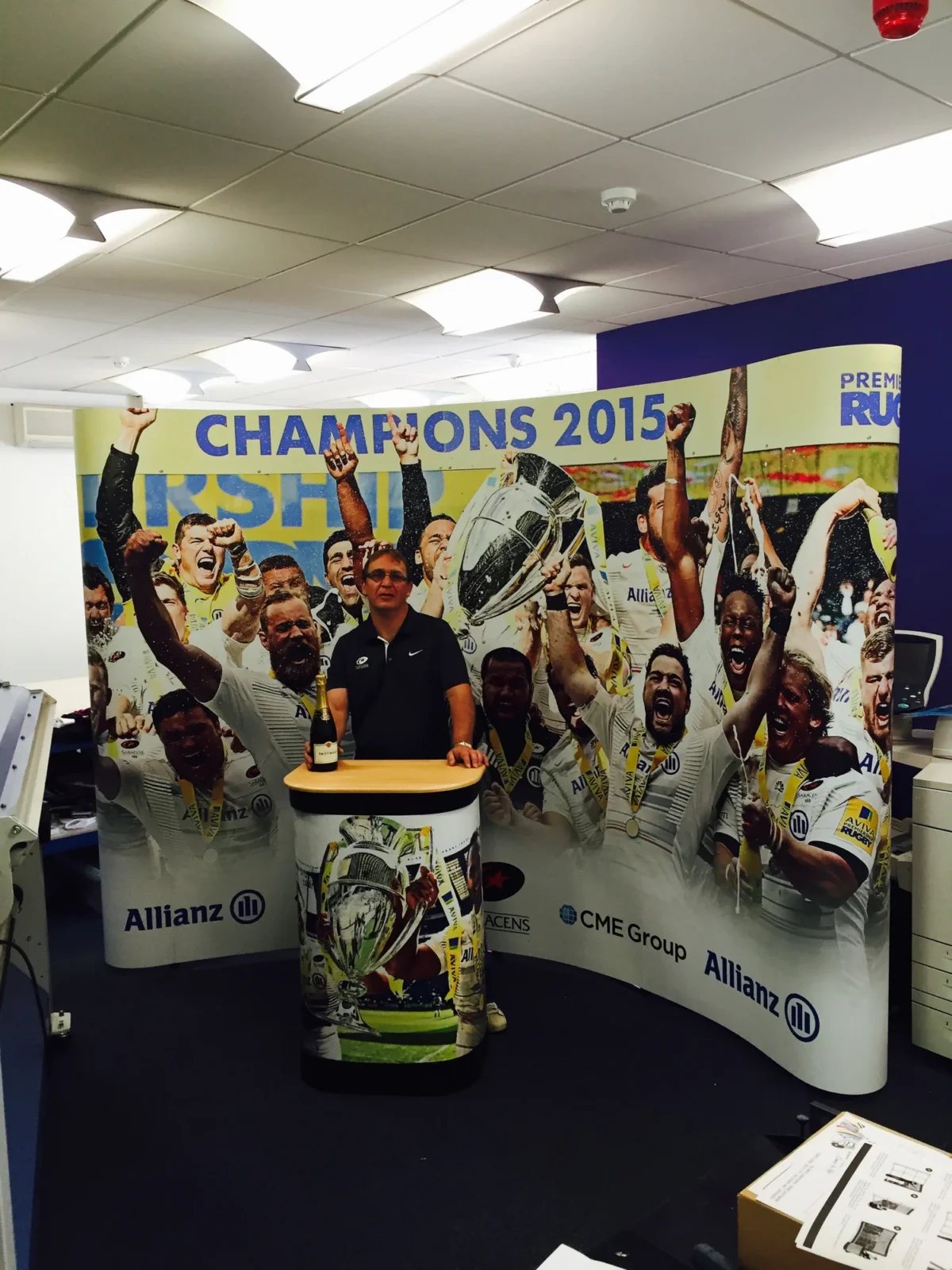 Man beside rugby champions 2015 celebration mural and champagne