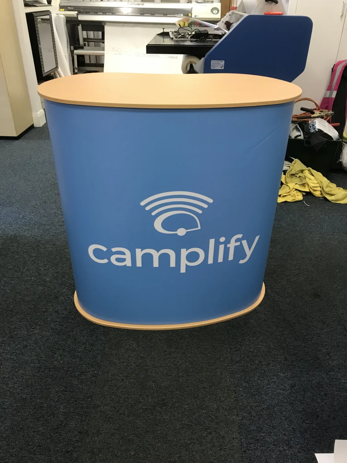 Blue Camplify branded exhibition counter in a workshop