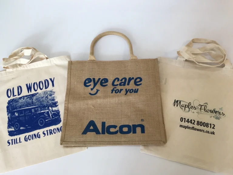 Three branded reusable shopping bags, including a central jute bag