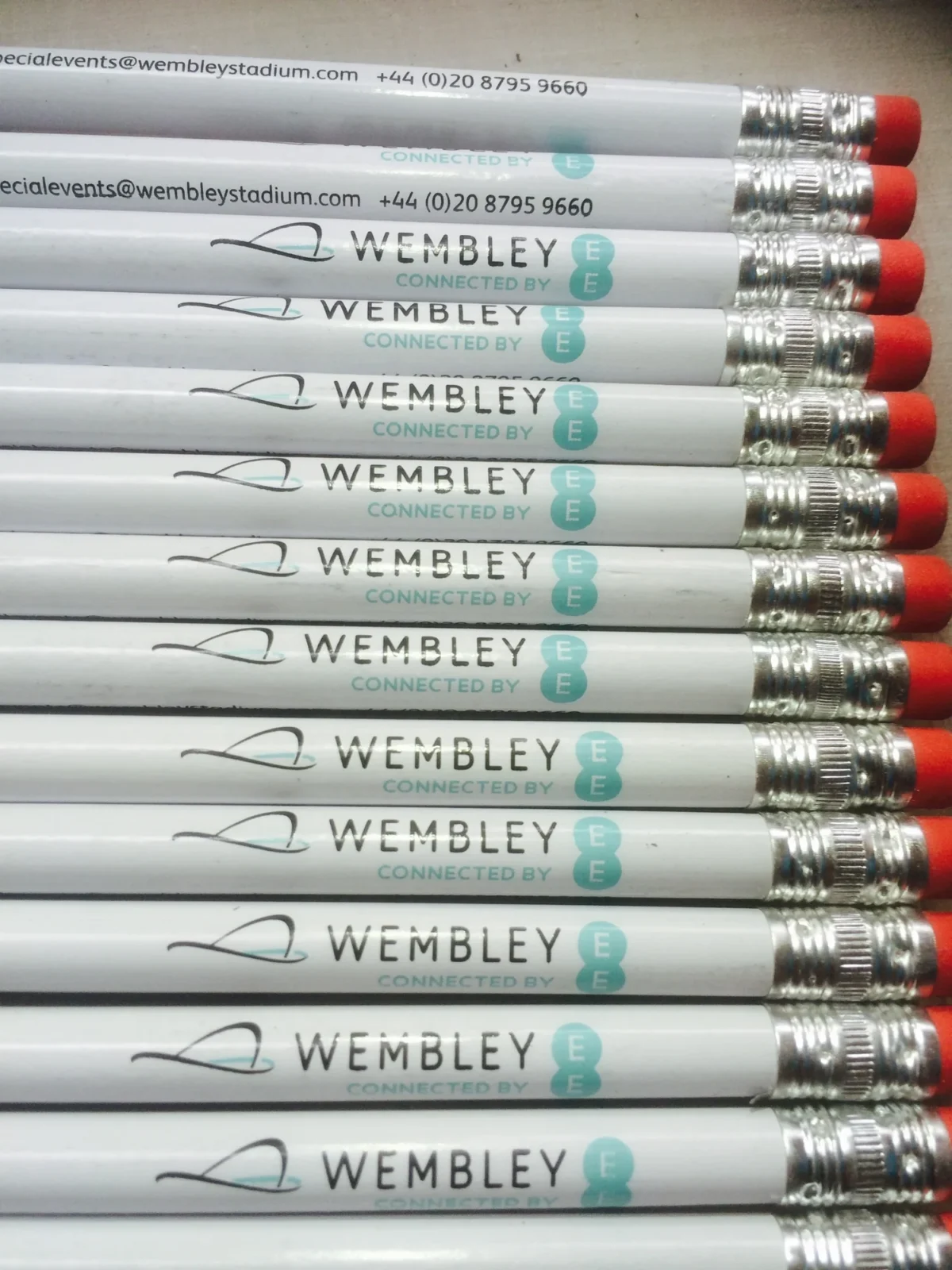 Stack of Wembley branded white pencils with red erasers