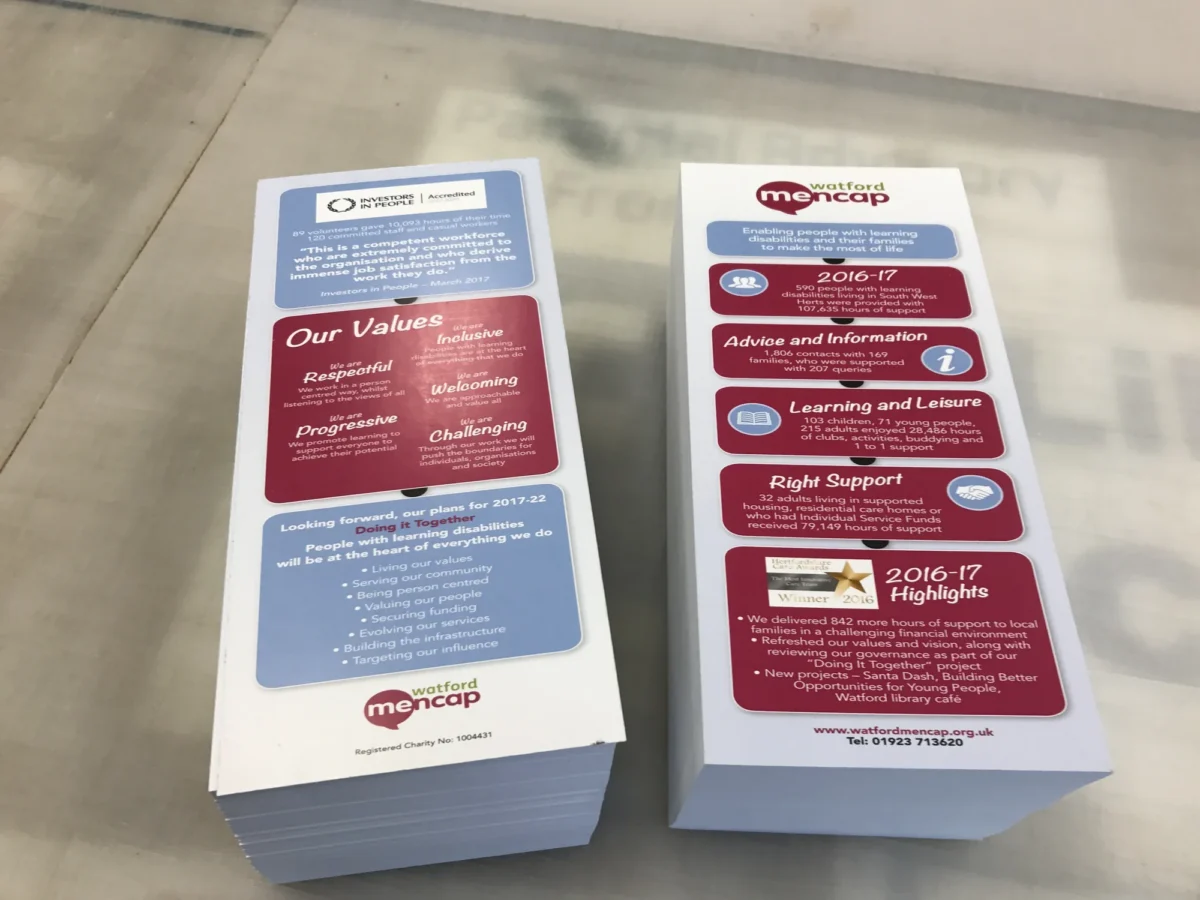 Two stacks of Watford Mencap annual report leaflets