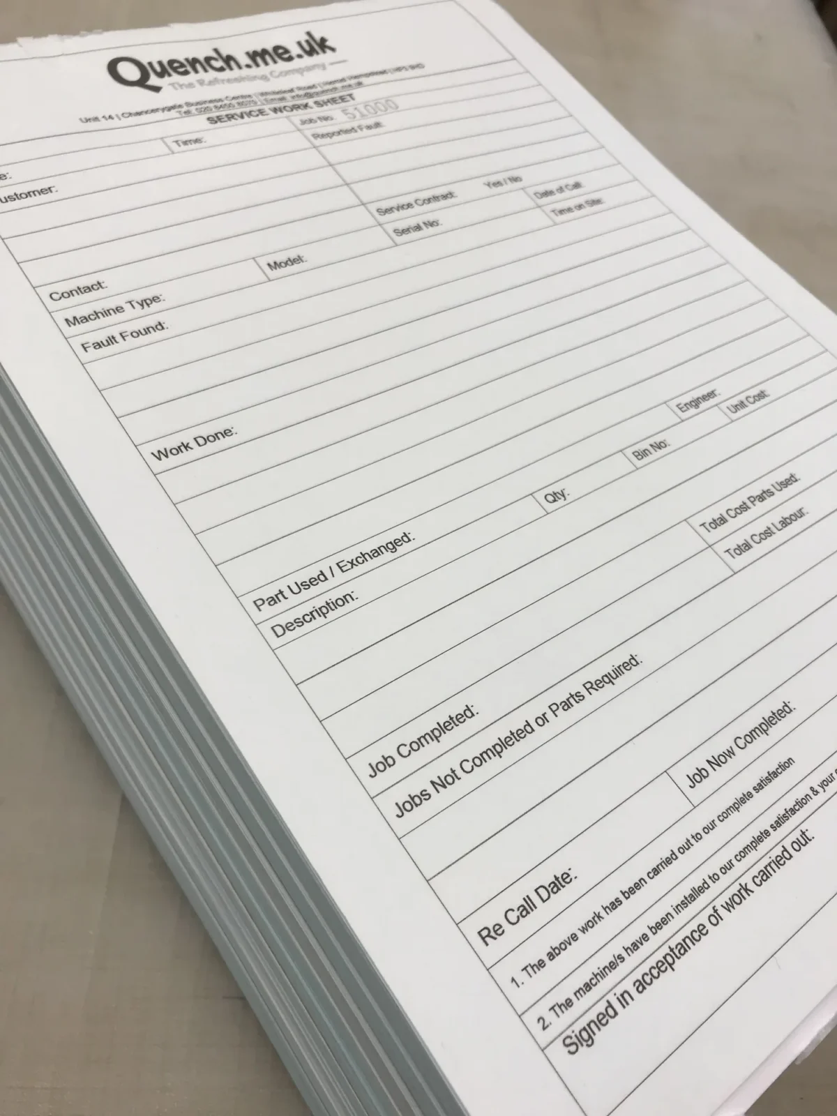 Stack of Quench service work sheets on a table