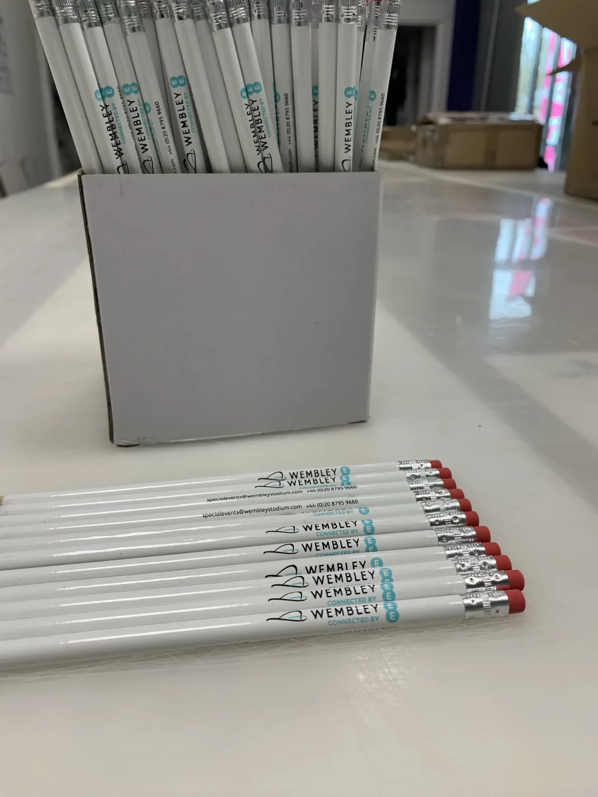 Box of Wembley branded white pencils on a table