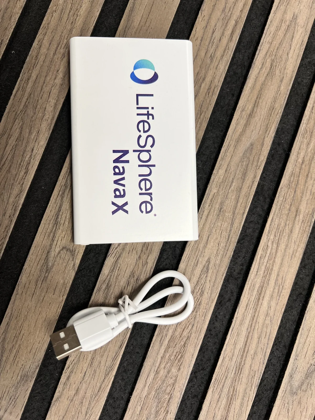 LifeSphere NavaX device with white USB charging cable