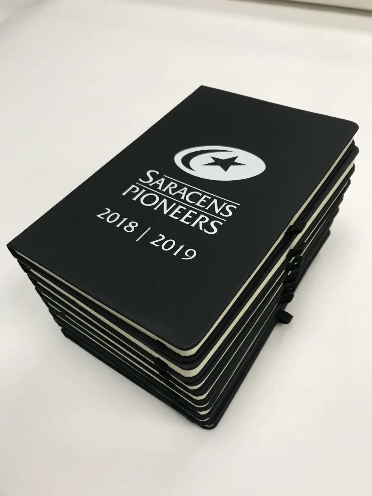 Stack of Saracens Pioneers notebooks