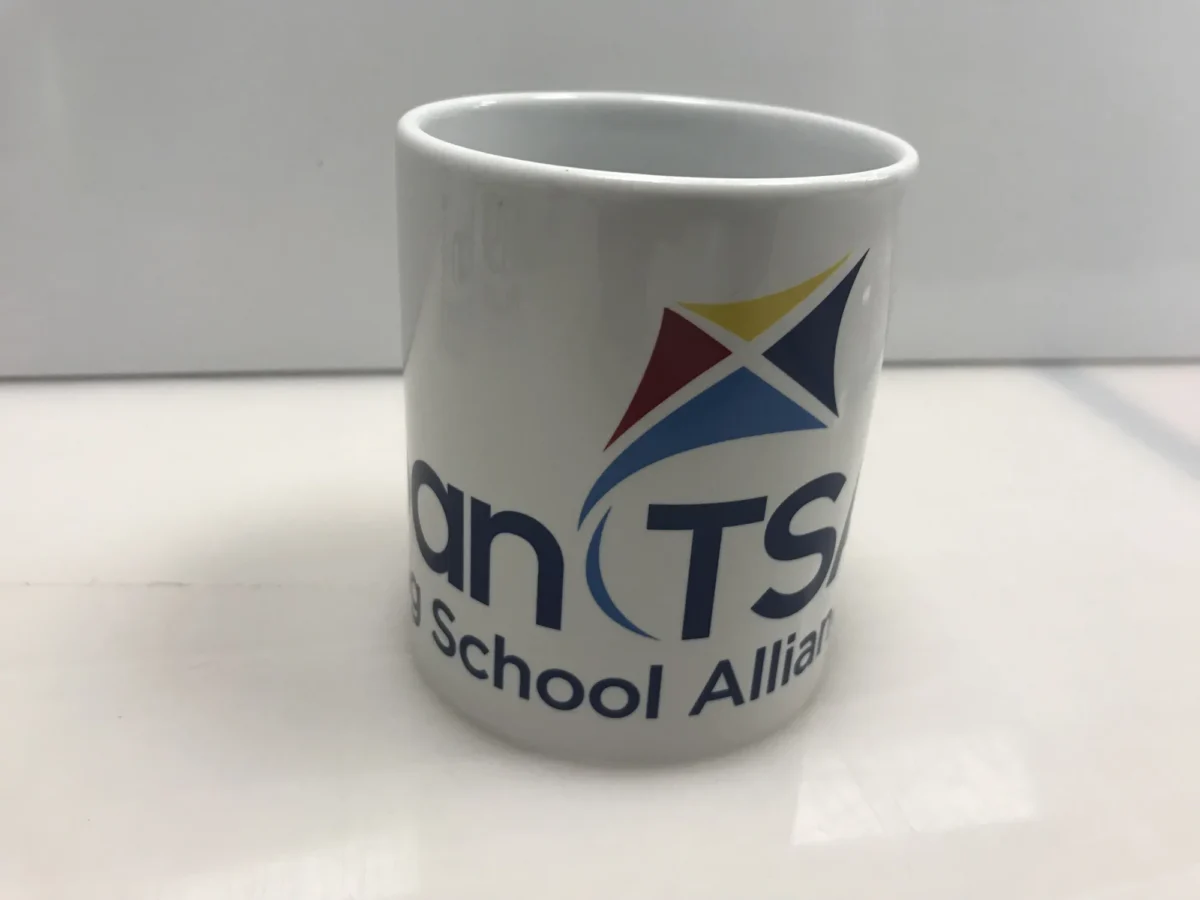 White mug displaying TCTS School Alliance logo