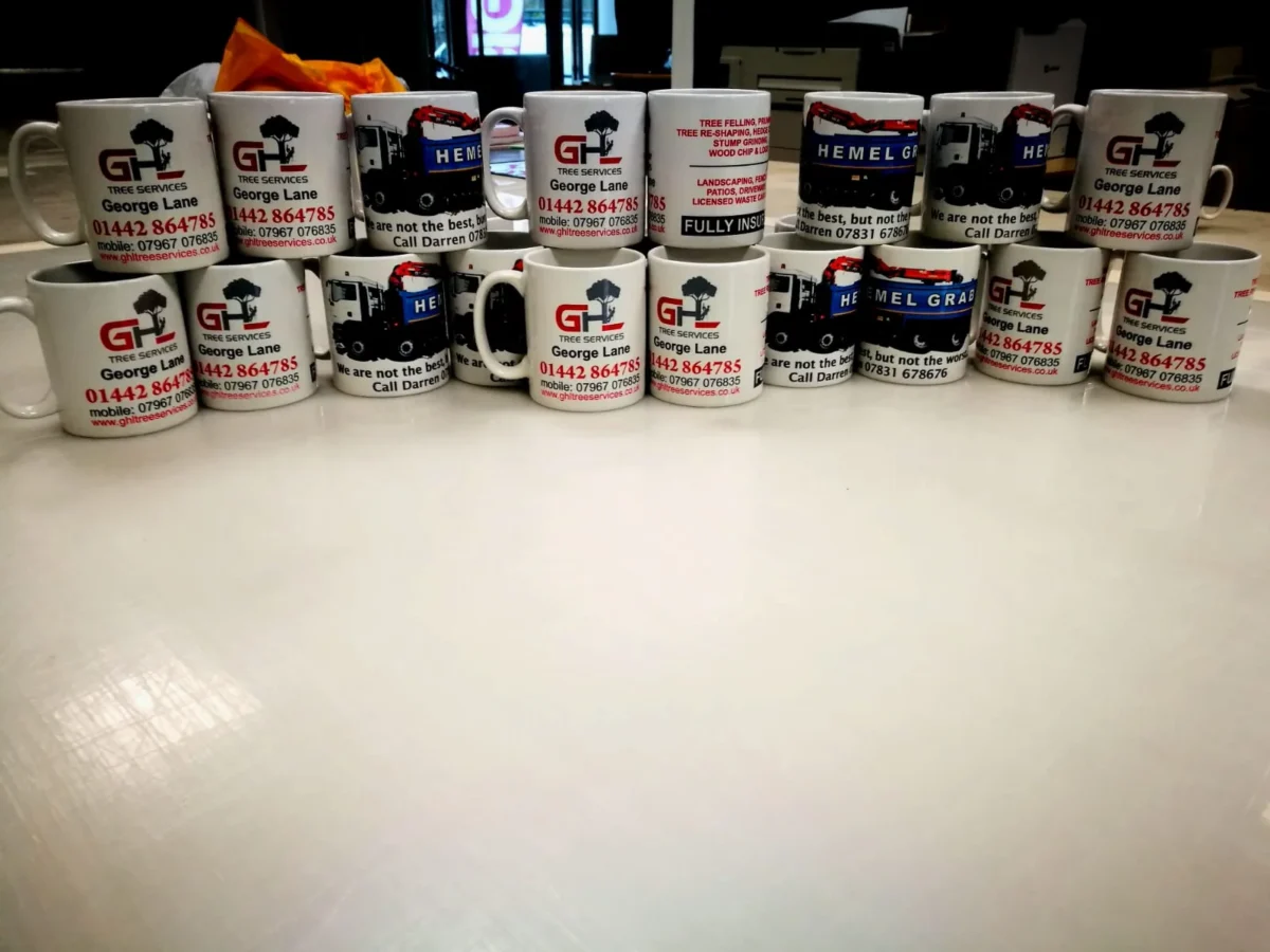 Branded George Lane Tree Services mugs displayed on counter