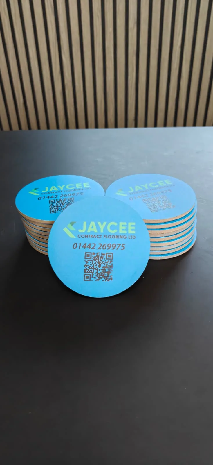 Blue Jaycee Contract Flooring branded round coaster stack