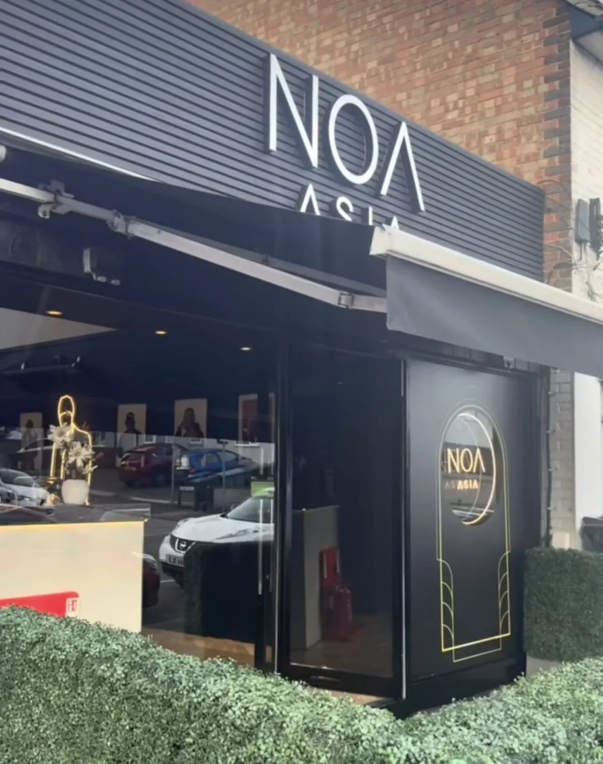 NOA Asian restaurant entrance with black signage and gold logo
