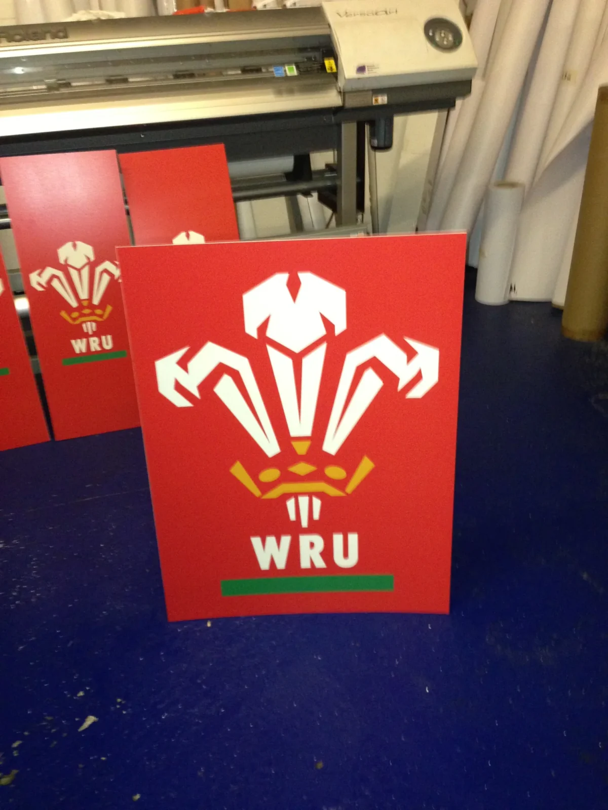 Red WRU logo panels beside a vinyl cutting machine