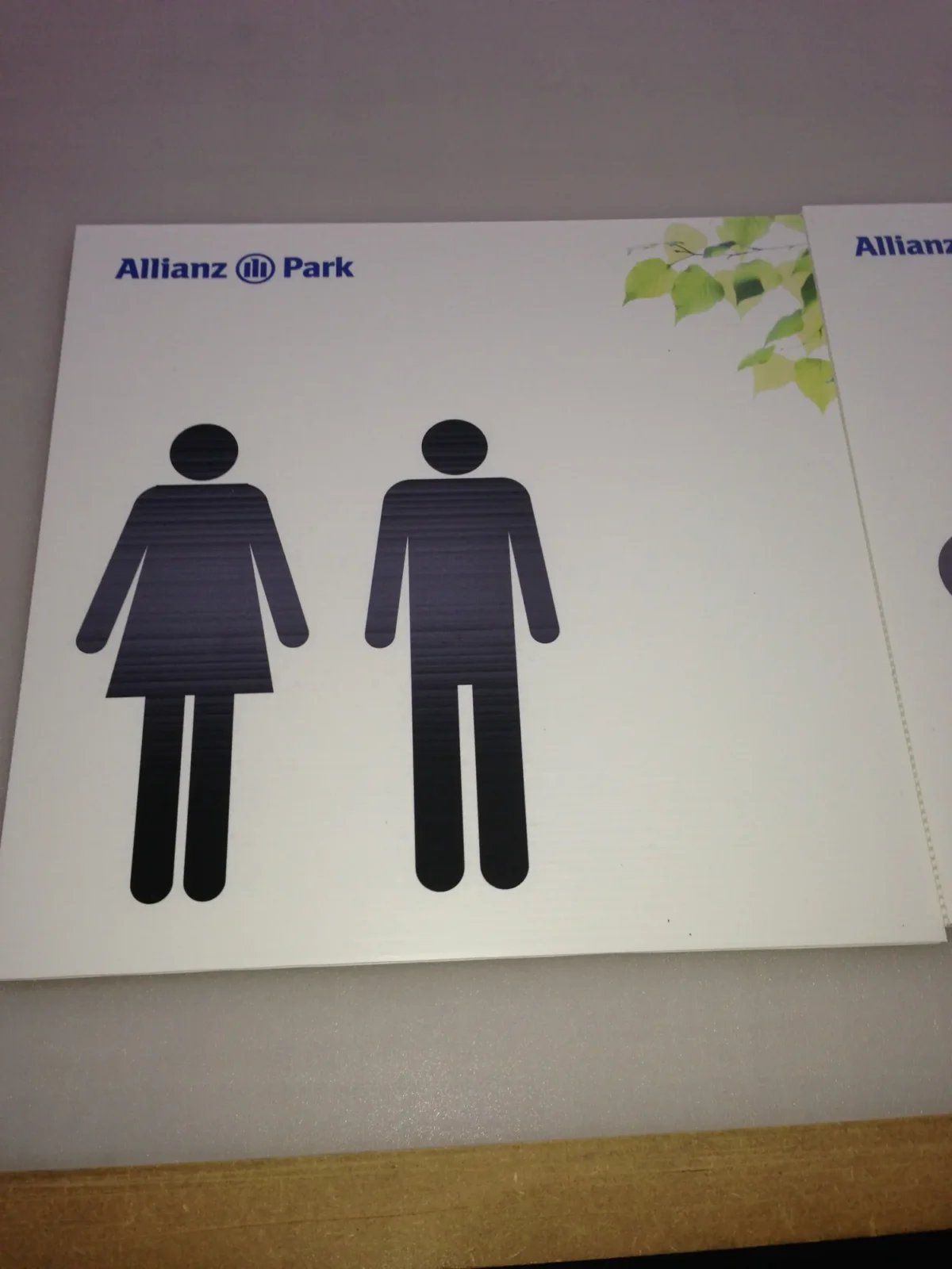 Allianz Park sign showing female and male toilet symbols