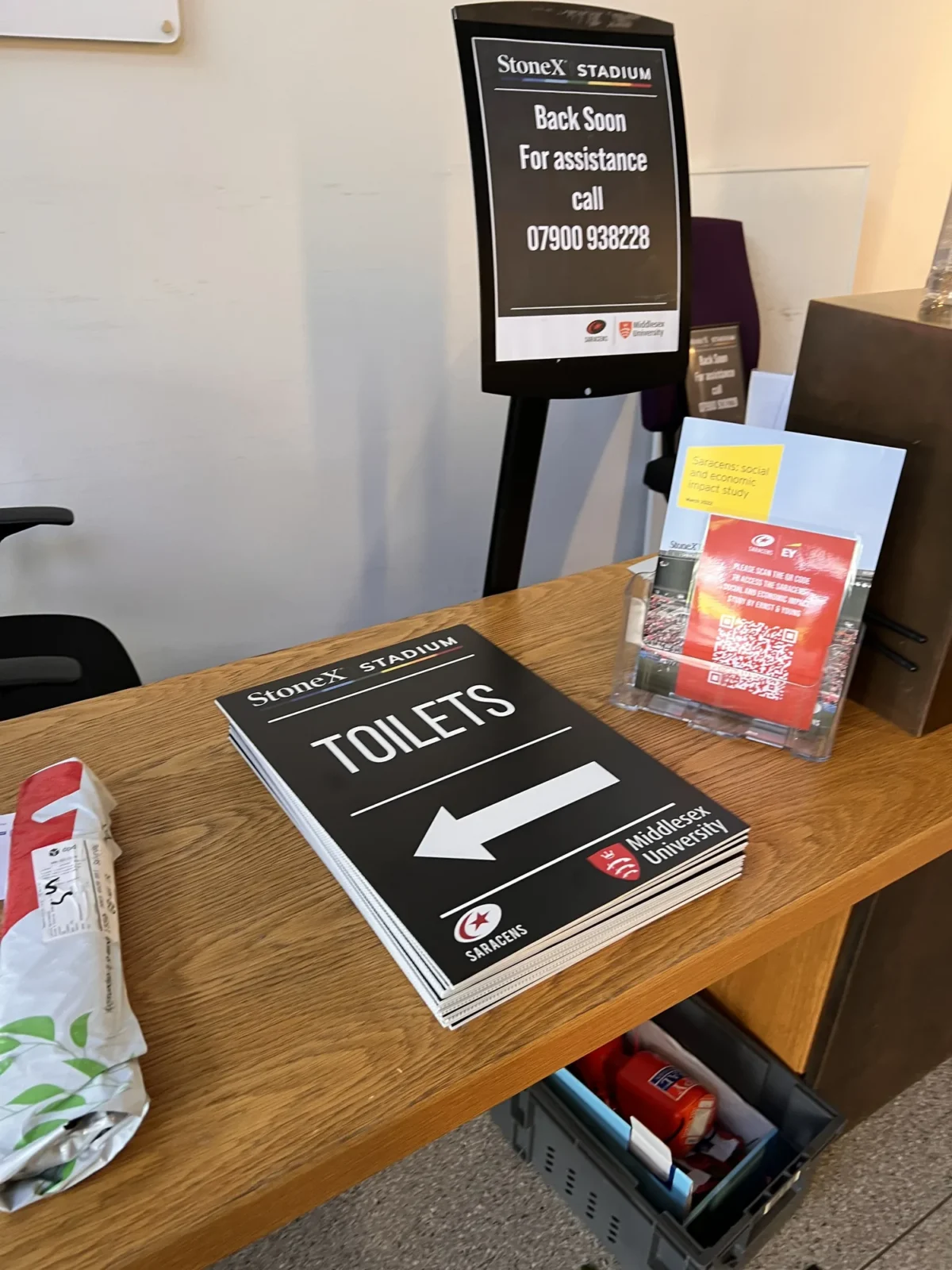 Toilet direction signs on StoneX Stadium reception desk