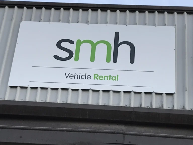 SMH Vehicle Rental sign on corrugated metal building