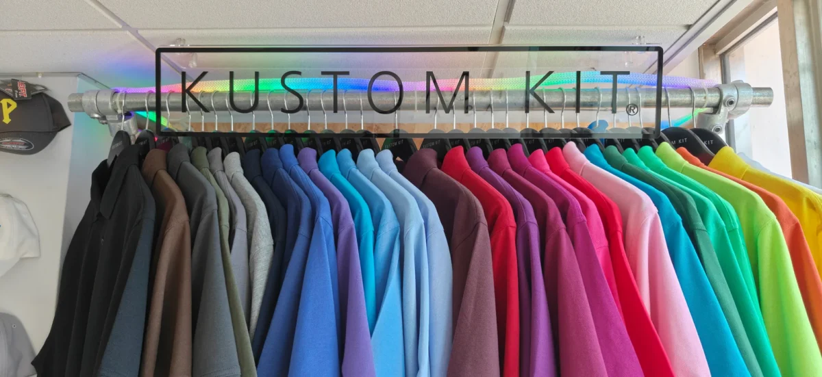 Colourful polo shirts displayed beneath Kustom Kit sign
