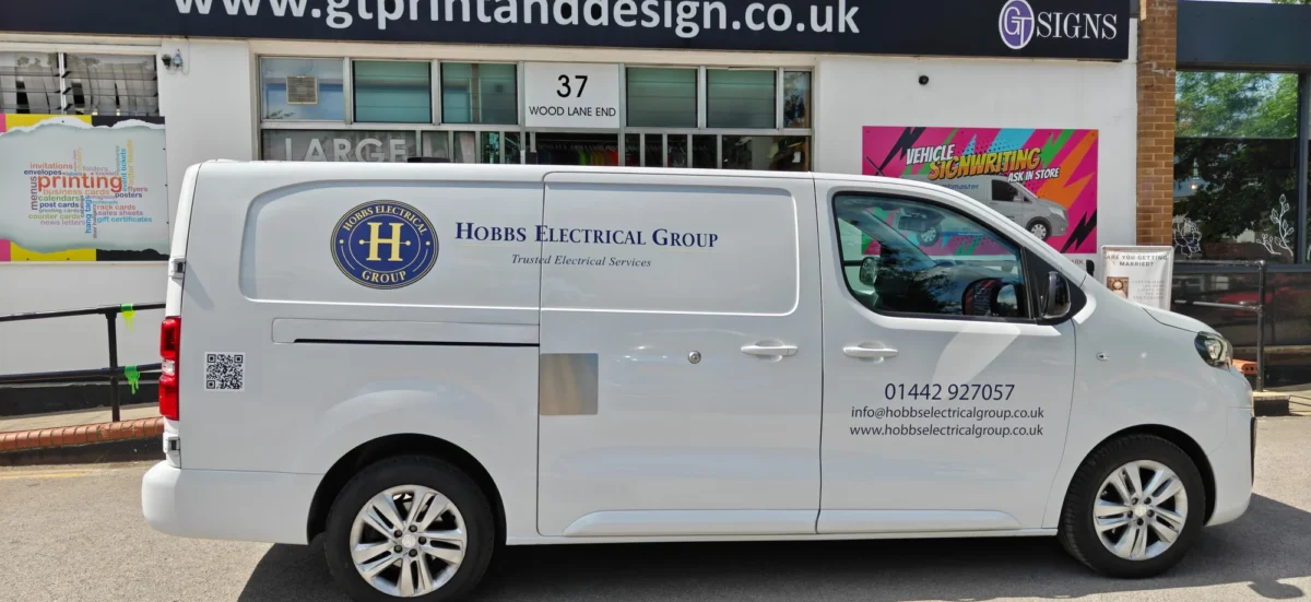 Hobbs Electrical Group branded white service van outside signage shop