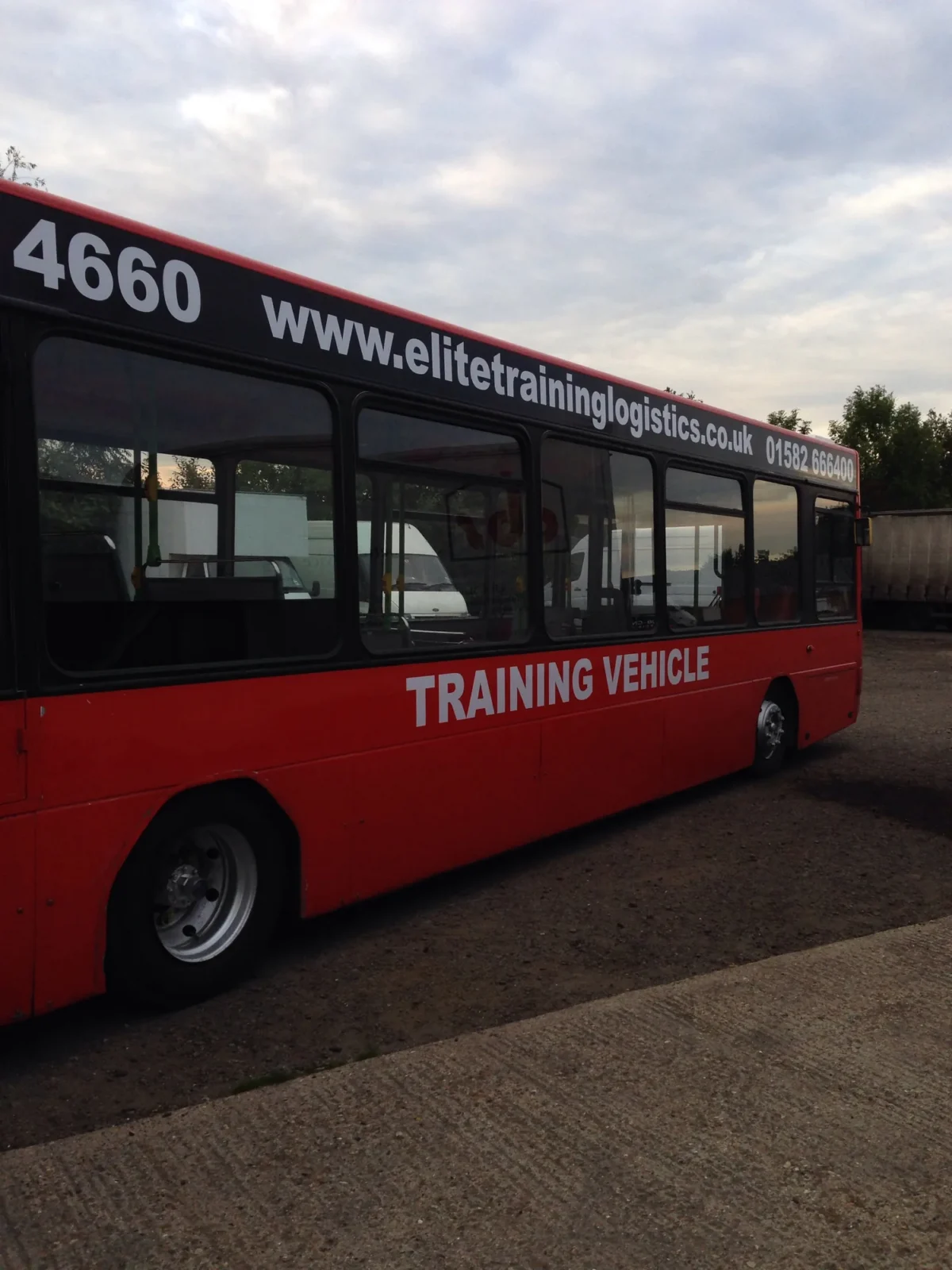 Red bus marked training vehicle parked outdoors