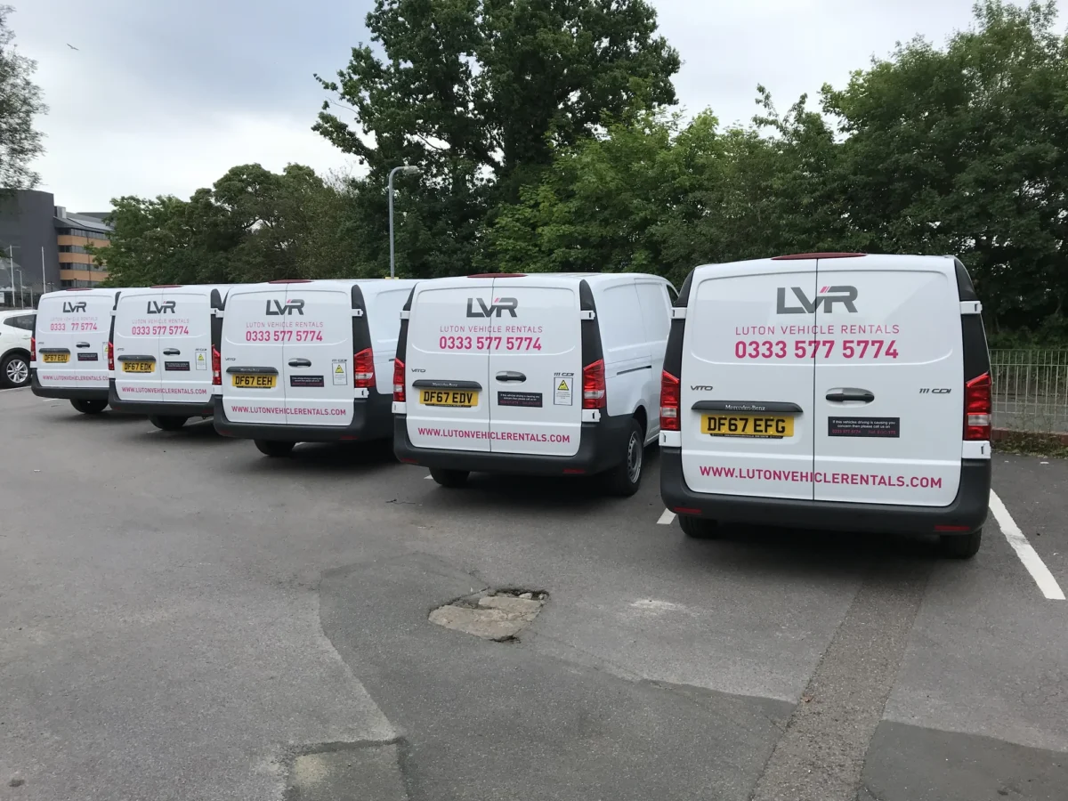 Four Luton Vehicle Rentals vans parked in a row