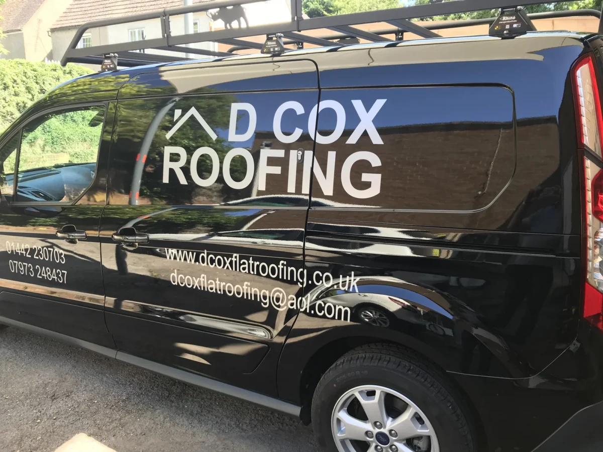 DCox Roofing branded black van with roof rack